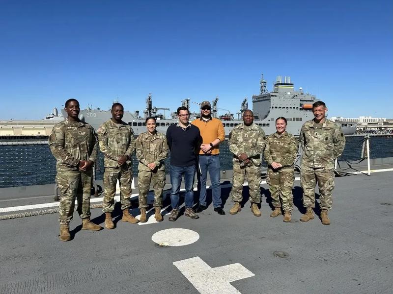 Nick Mann '26 stands for a photo with colleagues on deck of a U.S. Navy ship.