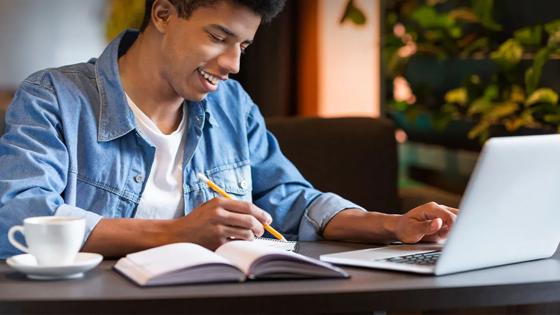 young man taking classes on a laptop