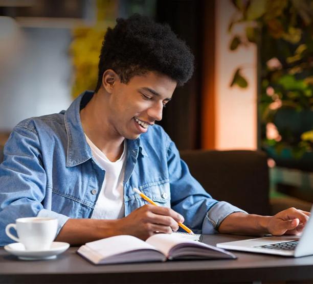 young man taking classes on a laptop