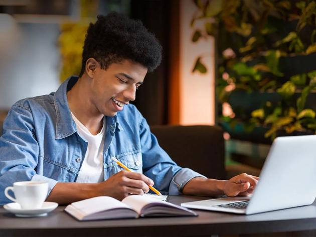 young man taking classes on a laptop
