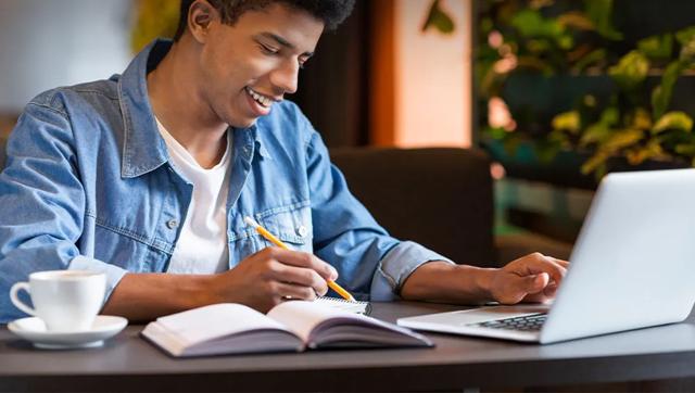 young man taking classes on a laptop