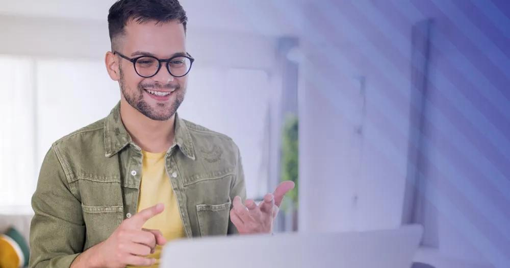 Man smiling while participating in an online course on a laptop.