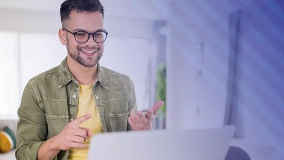 Man smiles looking at a laptop
