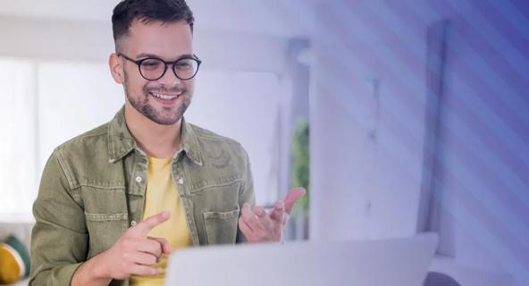 Man smiling while participating in an online course on a laptop.