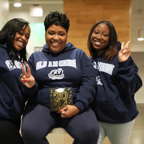 Celeste Harrell sits between her two daughters as they celebrate her graduation.