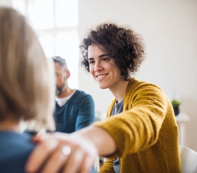 A counselor encourages a client in a group session