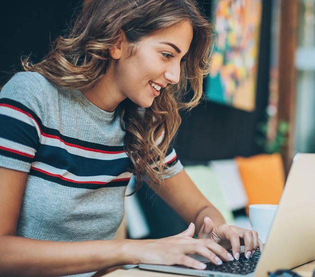 Female student registering for summer courses on her laptop.