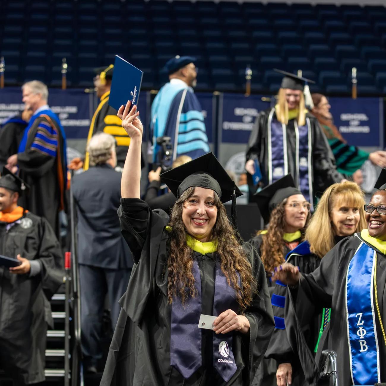 A graduating ODUGlobal student celebrates while walking in the Commencement ceremony.