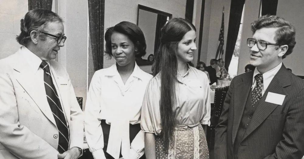 Alumni gathered and speaking at a university event.