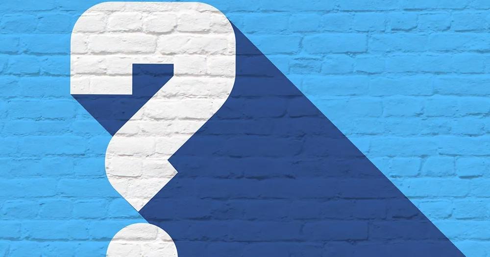 Question mark symbol on the wall representing questions about enrolling in an online degree.