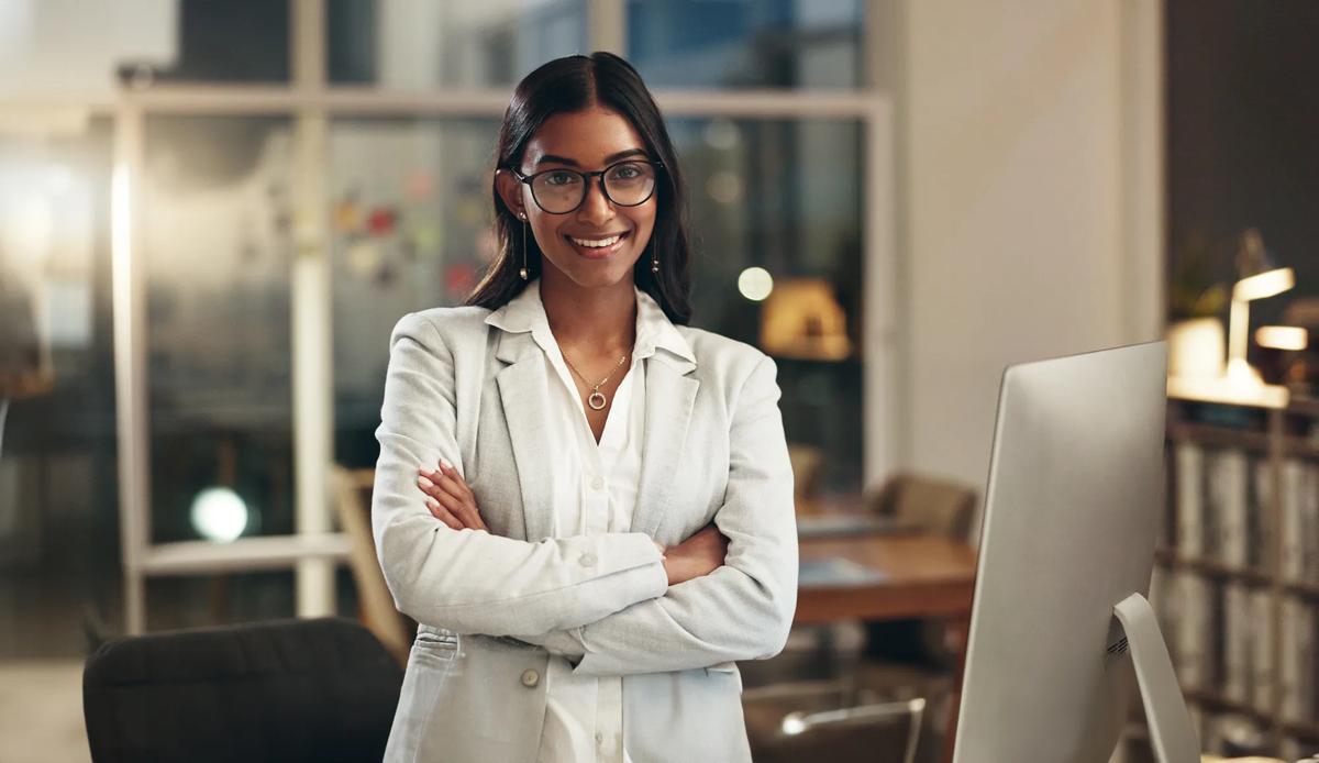Professional woman standing confidently with arms crossed.