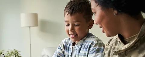 Military woman with child sitting at computer