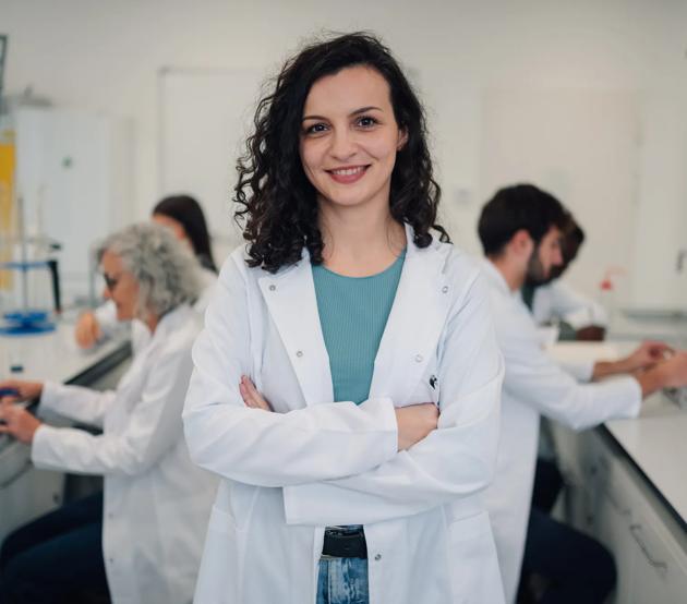 Woman scientist standing confidently in research laboratory