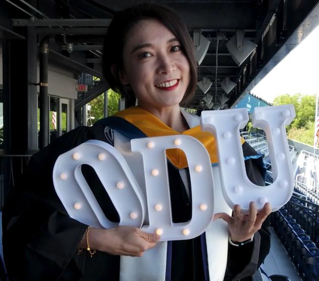 An ODUGlobal student celebrates at a reception for graduates before the commencement ceremony.
