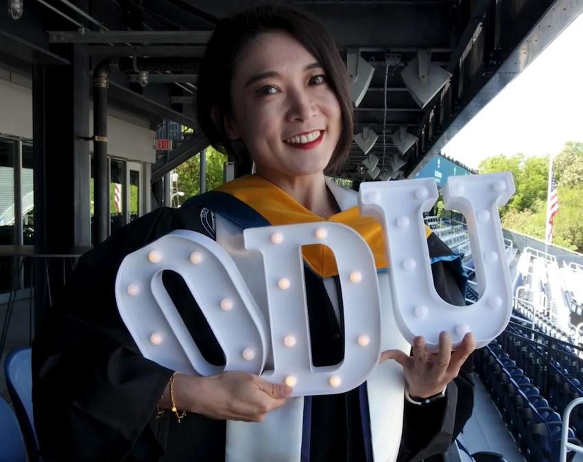 An ODUGlobal student celebrates at a reception for graduates before the commencement ceremony.