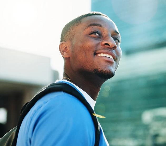 Happy, black man and thinking student in city for medical study, planning and healthcare opportunity. Smile, person or morning commute of learning internship, academic scholarship and nursing program
