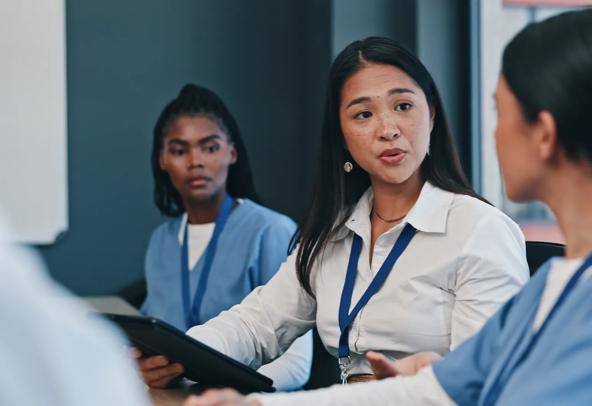 Medical and Health Professions Education (MHPE) instructor speaking directly to a student in a classroom.