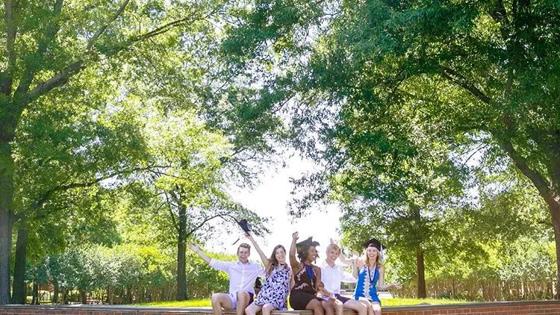 graduates sitting on Old Dominion University sign