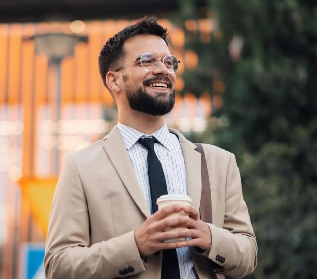 A young man in a business suit walks toward his office, optimistic about his future.