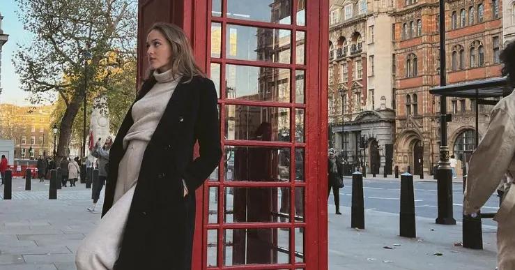 Zara Kelly, traveling through Europe while she earns her degree online, poses by a red phone booth in England.