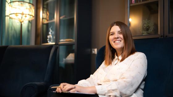 A seated female student leans back and smiles during a study break