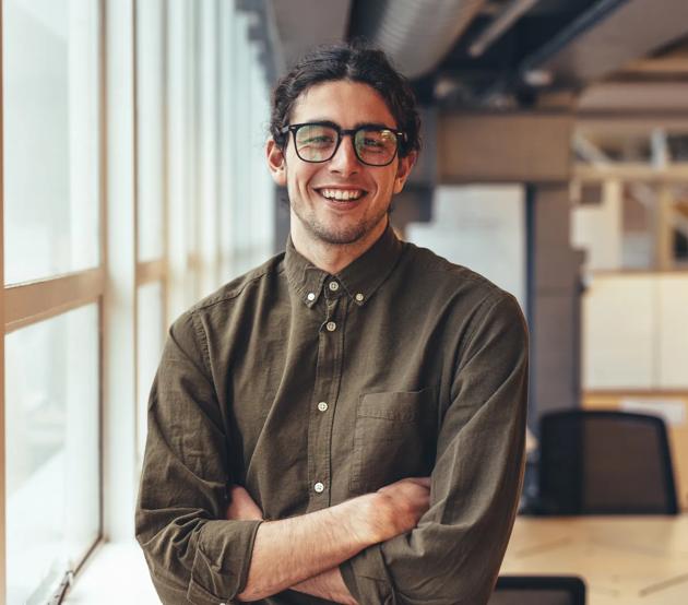 Happy_Businessman_Standing_in_Office