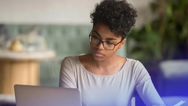 Woman researching online degree programs on her laptop
