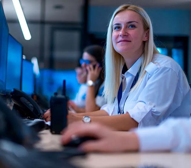 University staff member assisting students at a support desk.