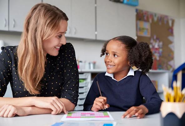 Encouraging educator working one-on-one with a student in a classroom.