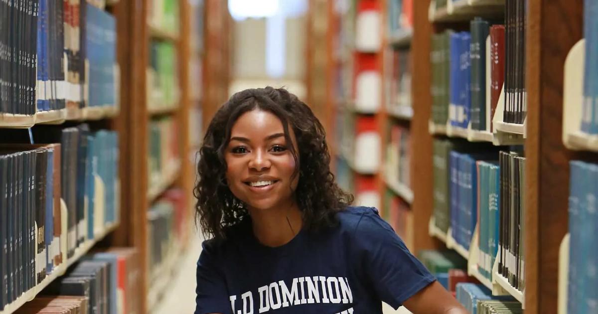 Smiling Old Dominion University student studying in library