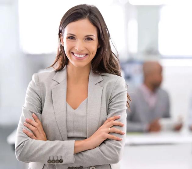 A young professional stands confidently in her new office.