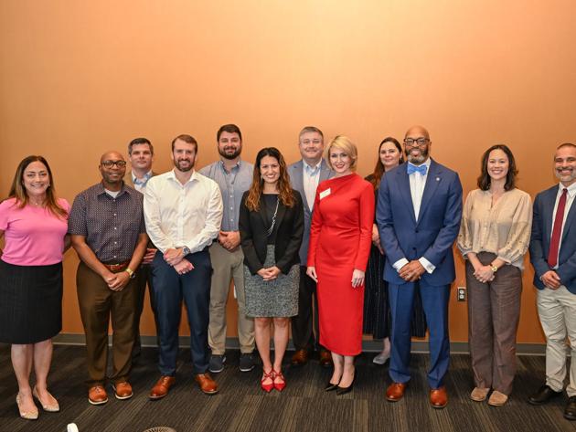Graduating students from the 10th cohort of the Public Sector Leadership graduate certificate pose for a group photo with ODU and USFCC leaders.