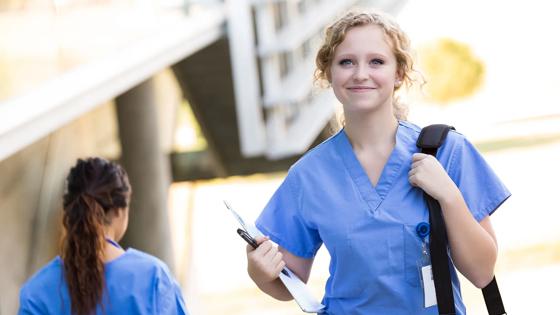 Nursing student with shoulder bag walking to class