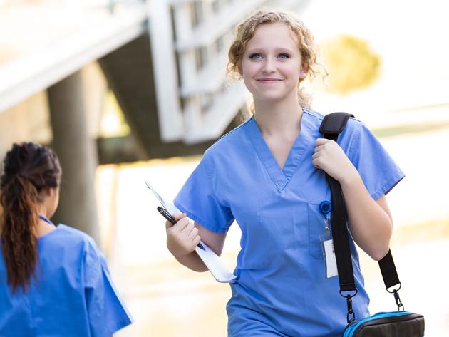 Nursing student with shoulder bag walking to class