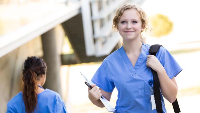 Nursing student with shoulder bag walking to class
