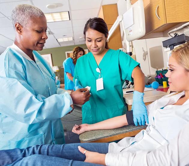 Student nurse and teaching nurse with patient