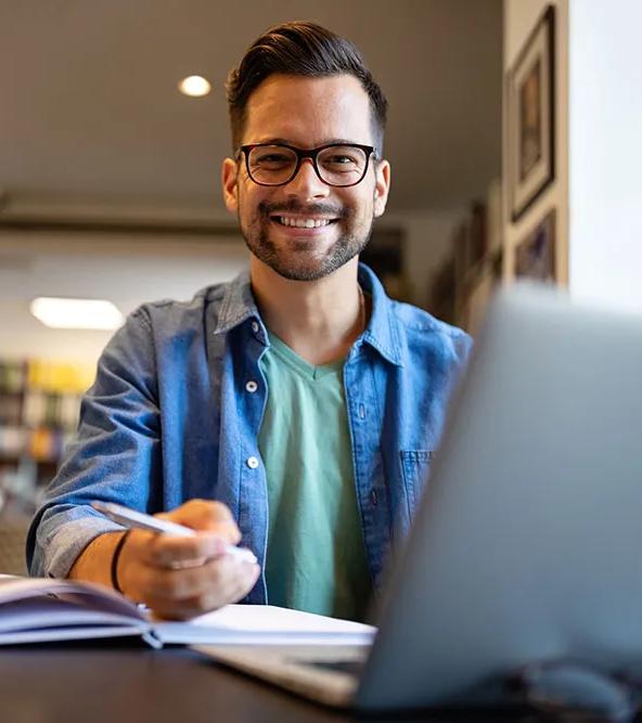Student at desk with computer and books