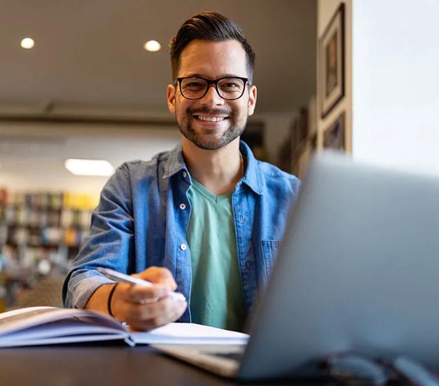 Student at desk with computer and books