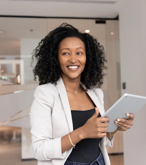 Smiling businesswoman looking aside distracted from using tablet in office