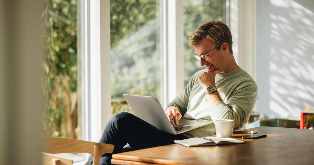 Young man using laptop and smiling