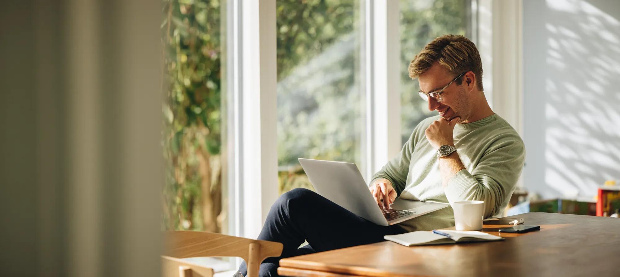 Young man using laptop and smiling