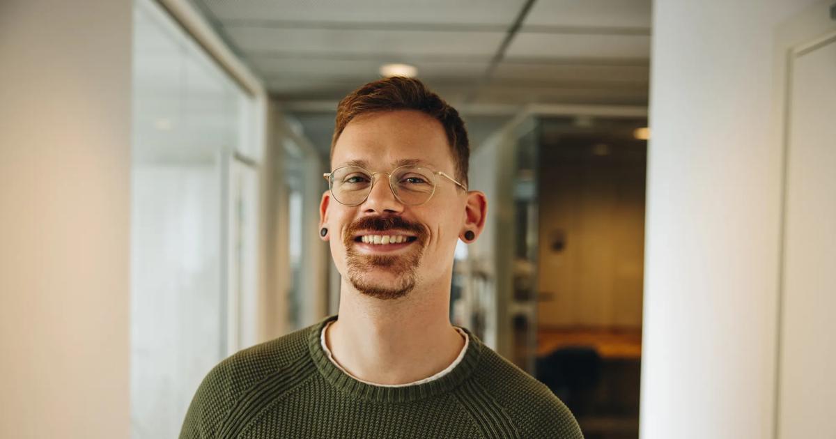 Portrait of smiling entrepreneur in office. Cheerful male executive in office corridor.